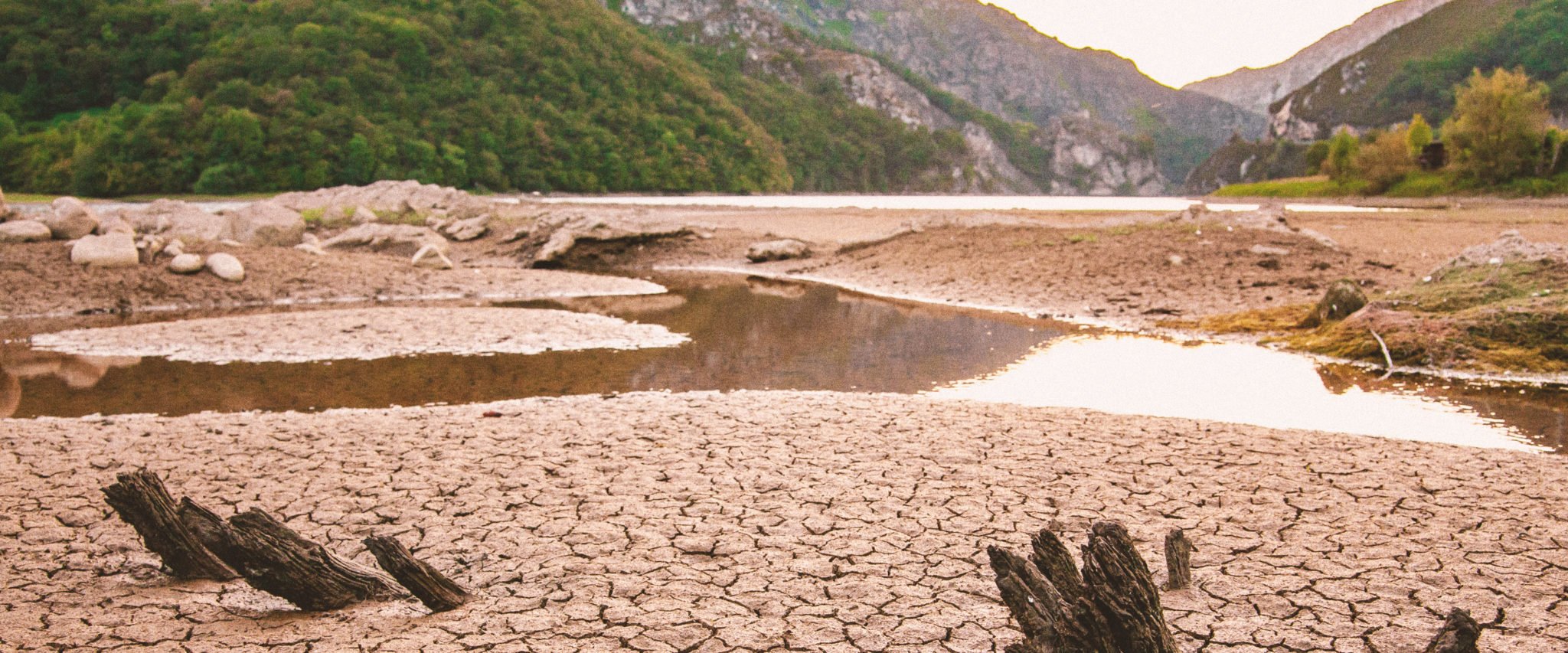 A large puddle sits in the middle of an orange, cracked landscape during California drought. Water resilience is necessary in the face of these droughts.